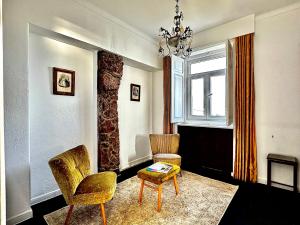 a living room with two chairs and a table and a chandelier at Casal Santa Virginia in Sintra