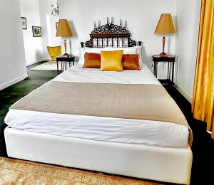 a bedroom with a large white bed with yellow pillows at Casal Santa Virginia in Sintra