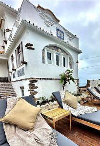 a house with chairs and a table in front of it at Casal Santa Virginia in Sintra