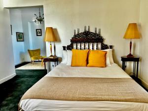 a bedroom with a large bed with yellow pillows at Casal Santa Virginia in Sintra