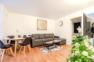 a living room with a couch and a christmas tree at Central apartment in Griffin Town in Montréal