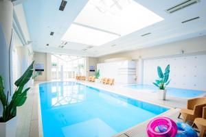 a large swimming pool with blue water in a building at Okinawa Grand Mer Resort in Okinawa City