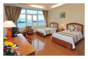 a hotel room with two beds and a table at Bamboo Green Hotel in Da Nang