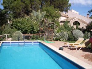 a swimming pool in a yard with a chair and a chair at Cortijo El Pino Retreat in Albuñuelas