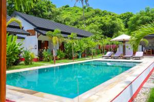 a swimming pool in front of a villa at Trytan Gerupuk Homestay in Bumbang