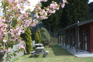 einen Garten mit einem Picknicktisch und rosa Blumen in der Unterkunft Owen River Tavern & Motels in Owen River