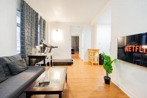a living room with a couch and a piano at Superbe appartement près McGill in Montréal