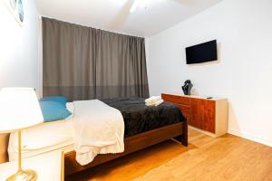 a bedroom with a bed and a television in it at Superbe appartement près McGill in Montréal