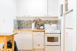 a kitchen with white appliances and a wooden table at Superbe appartement près McGill in Montréal