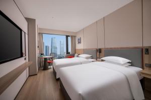 a hotel room with three beds and a flat screen tv at Holiday Inn Express Chongqing Central Park by IHG in Chongqing