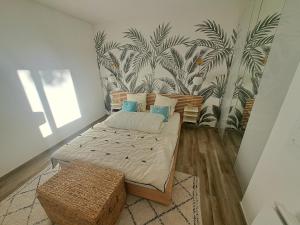um quarto com uma cama e um mural de palmeiras em Superbe appartement piscine, tennis, vue mer et décoré avec goût em Cassis mais 30 fotografias