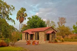 a group of chairs sitting in front of a building at Barabagh Deogarh - A Heritage Farm Stay in Devgarh
