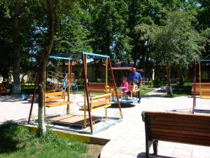 a man and a child on a swing set in a park at Hotel Bulaq in Turist