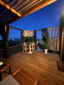 a deck with a view of the ocean at night at Glamour tinyhouse in Muret +3 photos