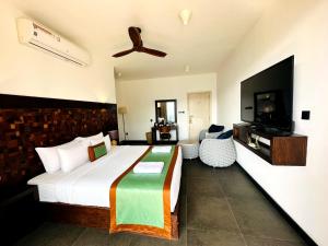 a bedroom with a large bed and a flat screen tv at Ella Flower Garden Resort in Ella