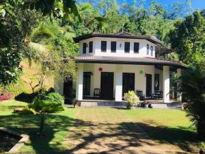 a white house with a lawn in front of it at Great villa lake resort in Karagoda