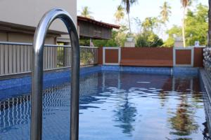 a swimming pool with a handrail in a house at Eagle Bay Hotel in Kuah