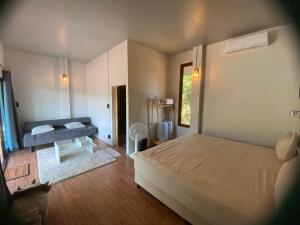a bedroom with a bed and a couch in it at Chiang Dao Story Camp in Ban Tham