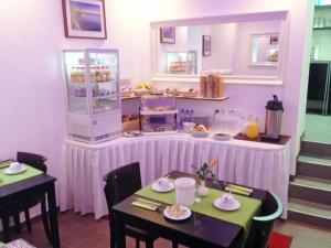 un ristorante con due tavoli e un bancone con cibo di Hotel Rest Inn a Bretten