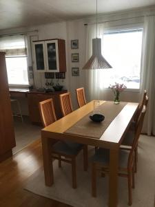 a dining room with a wooden table and chairs at Nordic Design House Lapinrinne in Rovaniemi