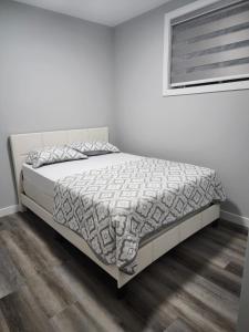 ein Schlafzimmer mit einem Bett mit einer weißen Tagesdecke in der Unterkunft lovely 2bed & 1 Bath Basement Suite for 4 guests in 