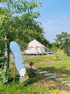 a blue chair sitting in the grass next to a tent at Habivillage in Long Bình