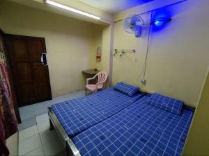 a hospital room with a blue bed and a chair at Jade Crown in Yangon