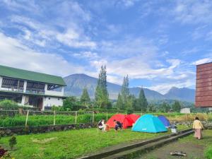 a group of people standing in a field with tents at Homestay Hidayah Sembalun in Sajang