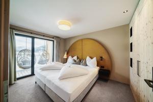 una camera da letto con un letto grande con una grande finestra di MONS suites wine passion a Tannheim