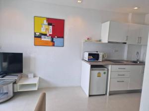 a kitchen with white cabinets and a microwave at Grandblue condominium 602 in Ban Tha Fat