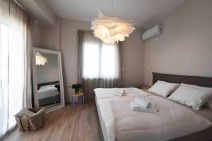 a bedroom with a large white bed and a mirror at Blue Nights Apartments Eretria in Eretria