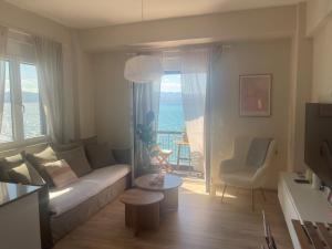 a living room with a couch and a view of the ocean at Blue Nights Apartments Eretria in Eretria