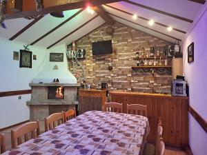 a dining room with a table and a fireplace at Guest House Lorian in Madzhare