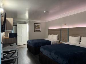 a hotel room with two beds and a television at Rodeway Inn in Ventura