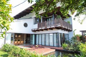 ein Haus mit Balkon und Terrasse in der Unterkunft Villa Brisa Tropical BMT in Buôn Kao