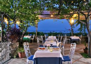 a table set up for a dinner party under a pergola at Hotel Pupetto in Positano