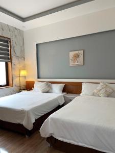 a bedroom with two beds and a large window at BinBin Homestay Đồng Hới Quảng Bình in Dong Hoi +36 photos