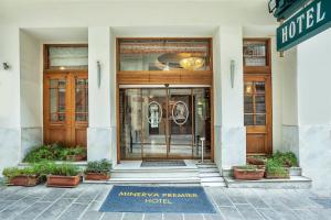 une entrée à un hôtel avec un panneau devant. dans l'établissement Minerva Premier Hotel, à Thessalonique