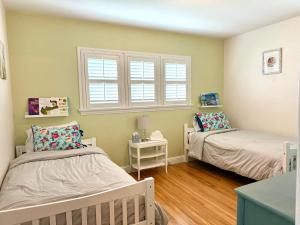 a bedroom with two beds and a window at Historic, Family-Friendly Home in Downtown in Bakersfield