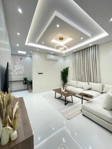 a living room with a white couch and a table at مساكن ورد الفندقية in Al Madinah