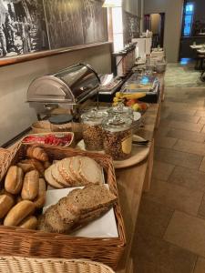 a buffet with bread and other foods on a counter at Hotel Courage Valkenburg in Valkenburg