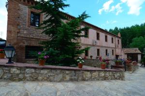 a building with potted plants on a stone wall at Caserón De La Fuente in Albarracín