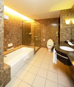 uma casa de banho com uma banheira, um WC e um lavatório. em Pacific Regency Hotel Suites em Kuala Lumpur