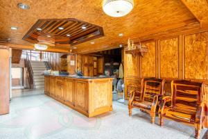 a kitchen with wooden cabinets and a counter with chairs at Chatsuree Mansion in Ubon Ratchathani