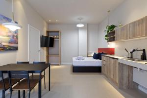 a kitchen and a bedroom with a bed and a table at Osito Hub - Colomer in Valencia