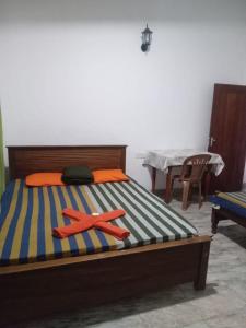 un dormitorio con una cama con dos naranjales. en Omashi sinharaja holiday resort, en Rakwana