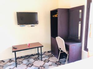 een kamer met een bureau, een tv en een tafel bij silent park in Sauraha