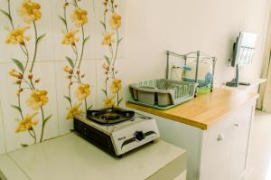a kitchen with a toaster on a counter with flowers on the wall at Comfort and Homey Studio at Parkland Avenue Apartment By Travelio in Tangerang