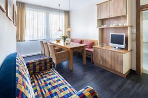ein Wohnzimmer mit einem Sofa und einem Tisch mit einem TV in der Unterkunft Ferienwohnung Strandhafer Norderney in Norderney