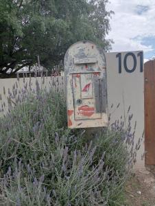 an old mail box sitting next to a fence at Studio 101 in Oudtshoorn +1 photo